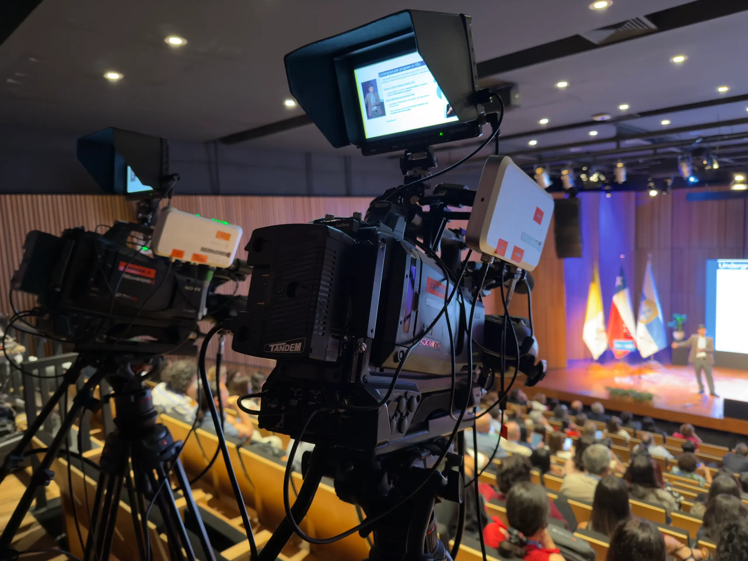 Cámaras de streaming cubriendo un evento corporativo en un auditorio