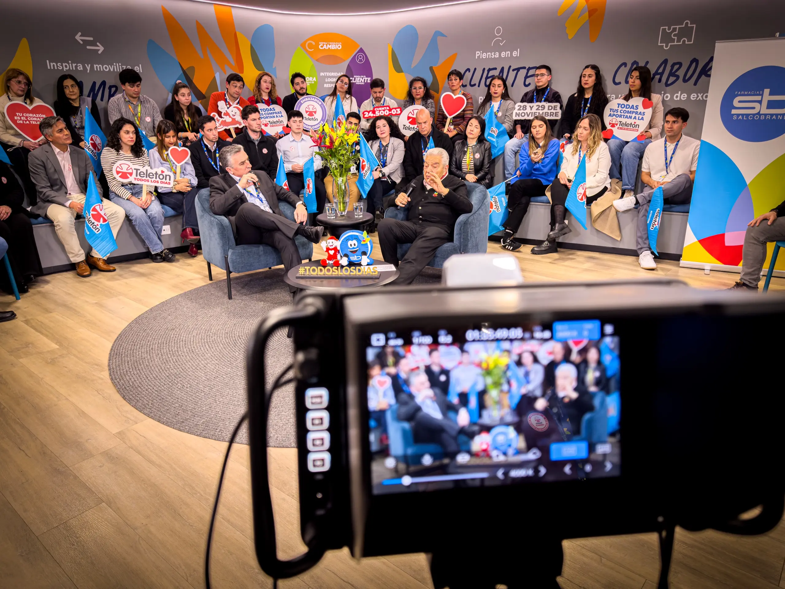 Cámara con monitor LCD grabando una transmisión en vivo de un evento corporativo